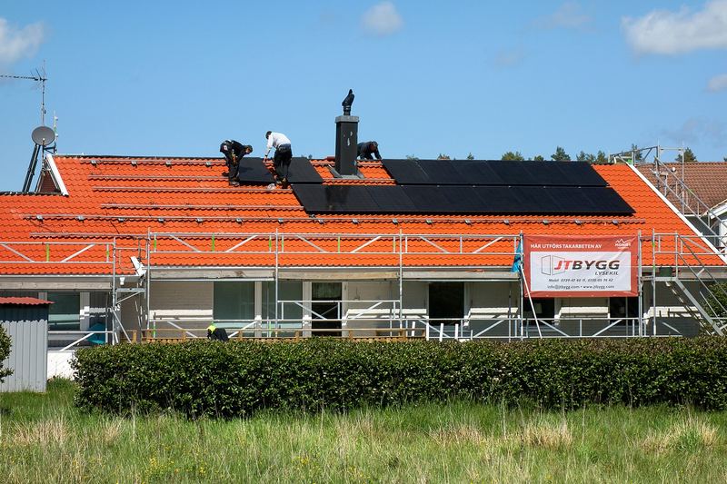 Solar installers working on a rooftop photovoltaic array